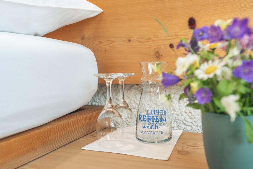 Hotel Hauser St. Moritz - Economy Doppelzimmer - Zimmerdetails Blumen und Mineralwasser